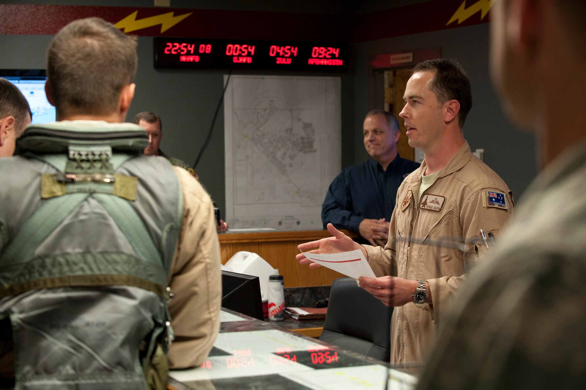 Royal Australian Air Force Flight Lt. Michael Galton, 389th Fighter Squadron assistant director of operations, briefs deploying aircrew at the 389th FS operations desk at Mountain Home Air Force Base, Idaho, April 21, 2013. The deploying Airmen will support combat operations in Southwest Asia with F-15E Strike Eagles. (U.S. Air Force photo/Staff Sgt. Roy Lynch) (Released)