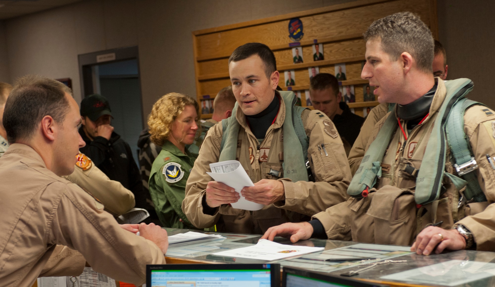 Royal Australian Air Force Flight Lt. Michael Galton (left), 389th Fighter Squadron assistant director of operations, speaks with U.S. Air Force Capt. Craig Sanders, 389th FS chief of mission planning, and Capt. Travis Stephens, 389th FS assistant director of operations, at the 389th FS operations desk at Mountain Home Air Force Base, Idaho, April 21, 2013. Members from the 389th FS deployed to Southwest Asia to assist ground commanders in combat operations. (U.S. Air Force photo/Staff Sgt. Roy Lynch) (Released)