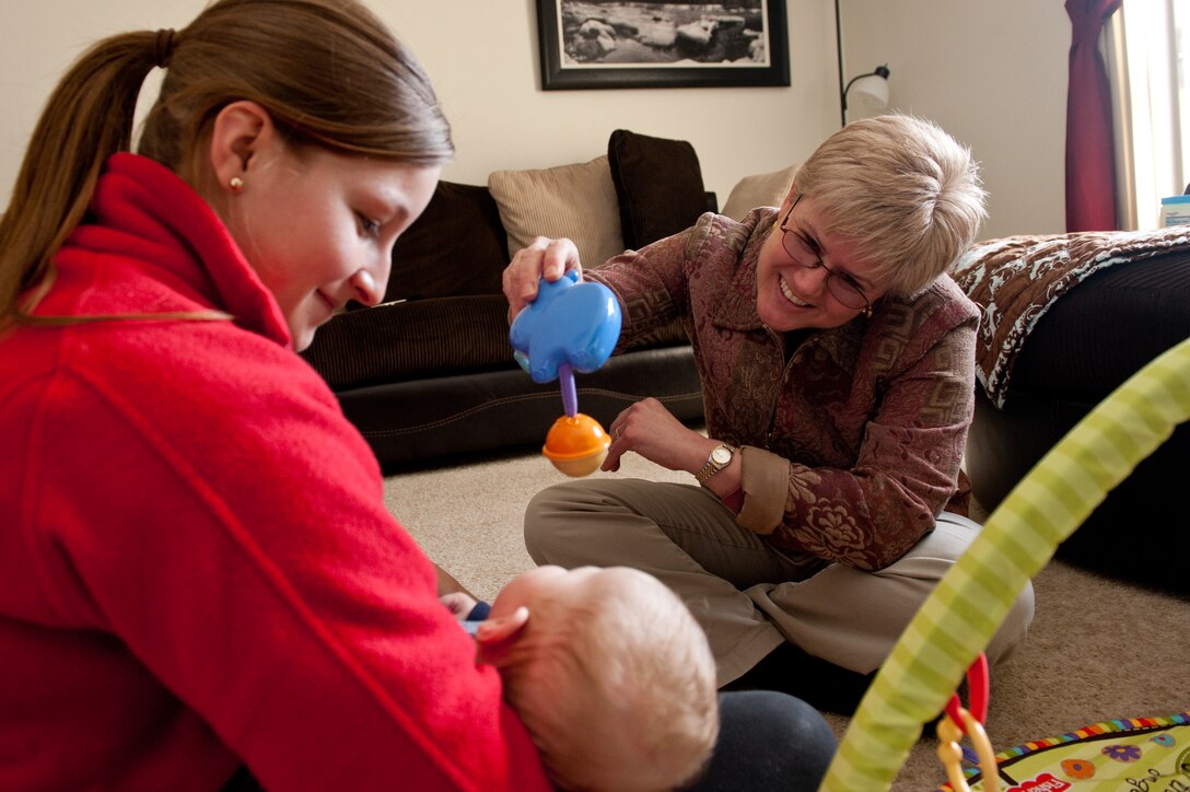 Helen Romeyn, 28th Medical Operations Squadron Family Advocacy Program nurse and New Parent Support Program manager, educates Danielle Burton, spouse of an Ellsworth Airman, and her 3-month old son, Kenneth, the importance of grabbing items during a home visit in Box Elder, S.D., April 15, 2013. The NPSP allows Romeyn to visit homes, on a volunteer basis, that are expecting babies or have children under 3, in an effort to educate families on child development, and military related stressors, de-stressing techniques. (U.S. Air Force photo by Airman 1st Class Kate Thornton-Maurer/Released)