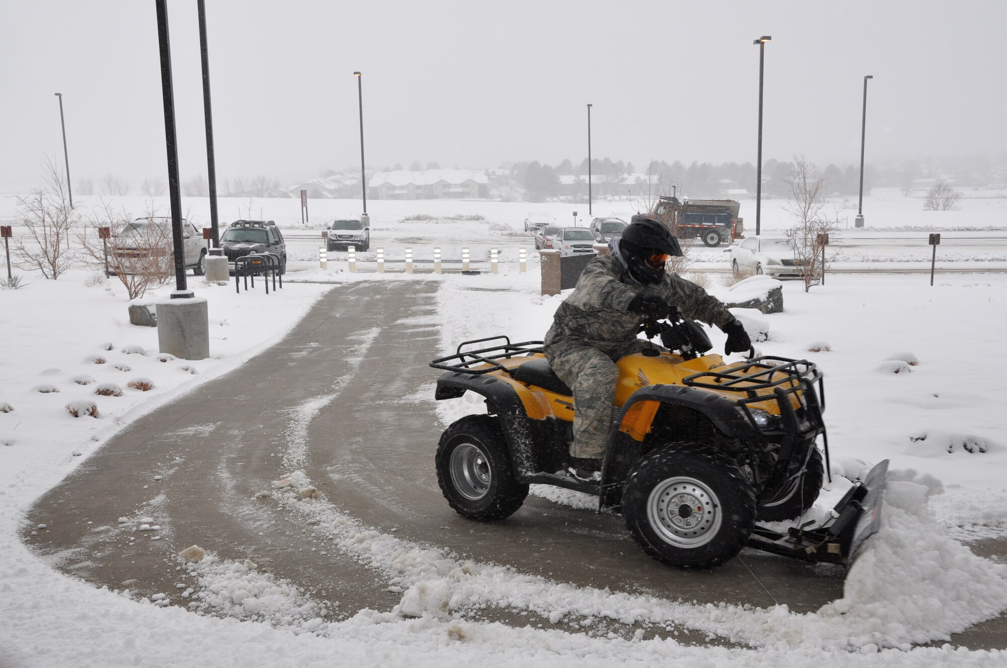 Master Sgt. Javier Castro operates an all terrain vehicle snow plow as he clears out the entrance to the Air Reserve Personnel Center building here today. Buckley Air Force Base had delayed reporting due to ice and snow accumulation. (U.S. Air Force photo/Tech. Sgt. Rob Hazelett)