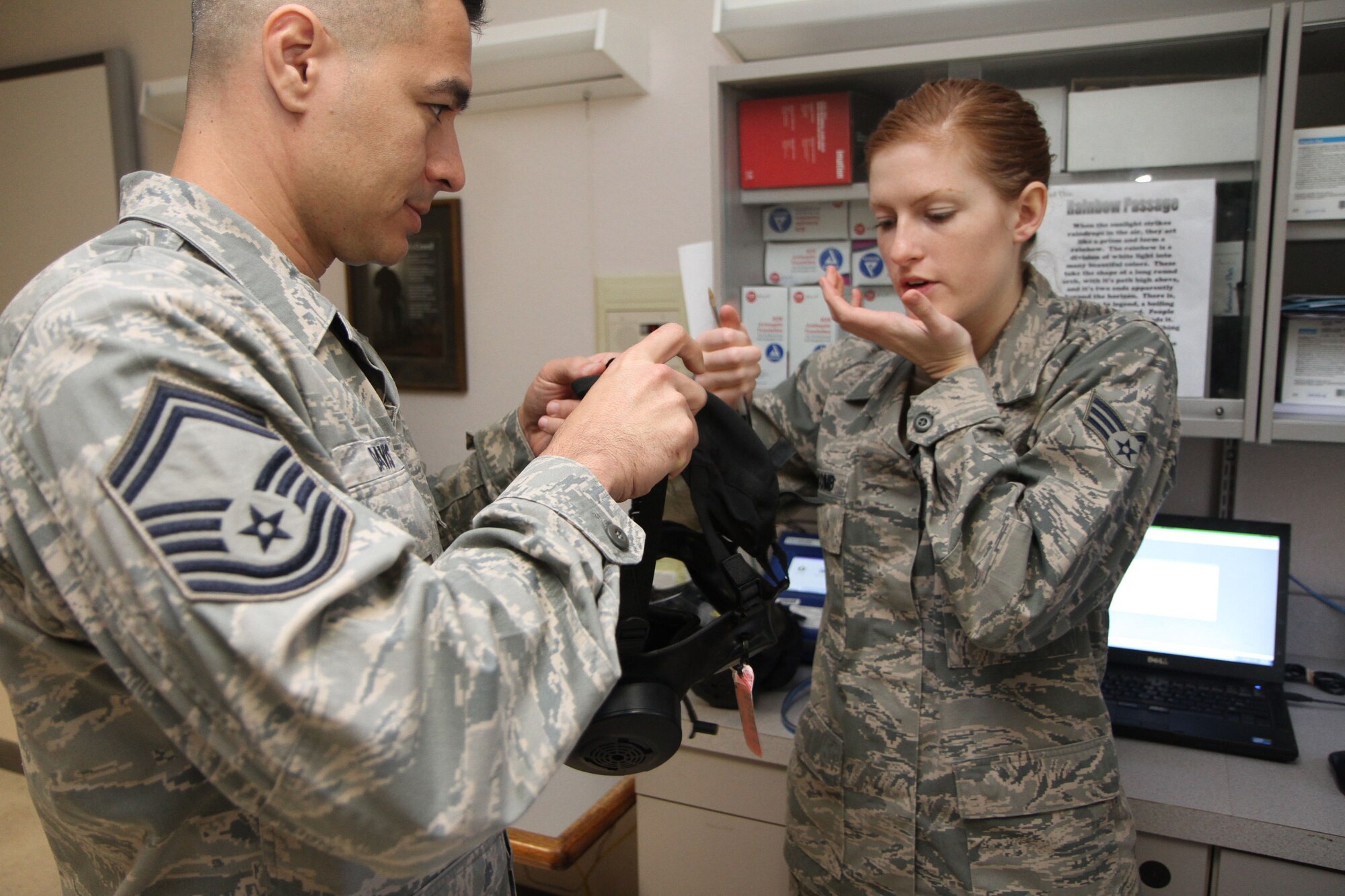 Senior Airman Morgan Newcomb demonstrates how to don the new M-50 gas mask to Senior Master Sgt. Harold Davis during the April UTA.  Davis was among dozens of 932nd Airlift Wing members that were measured and fitted for the new masks.  (U.S. Air Force photo/Tech. Sgt. Christopher Parr)