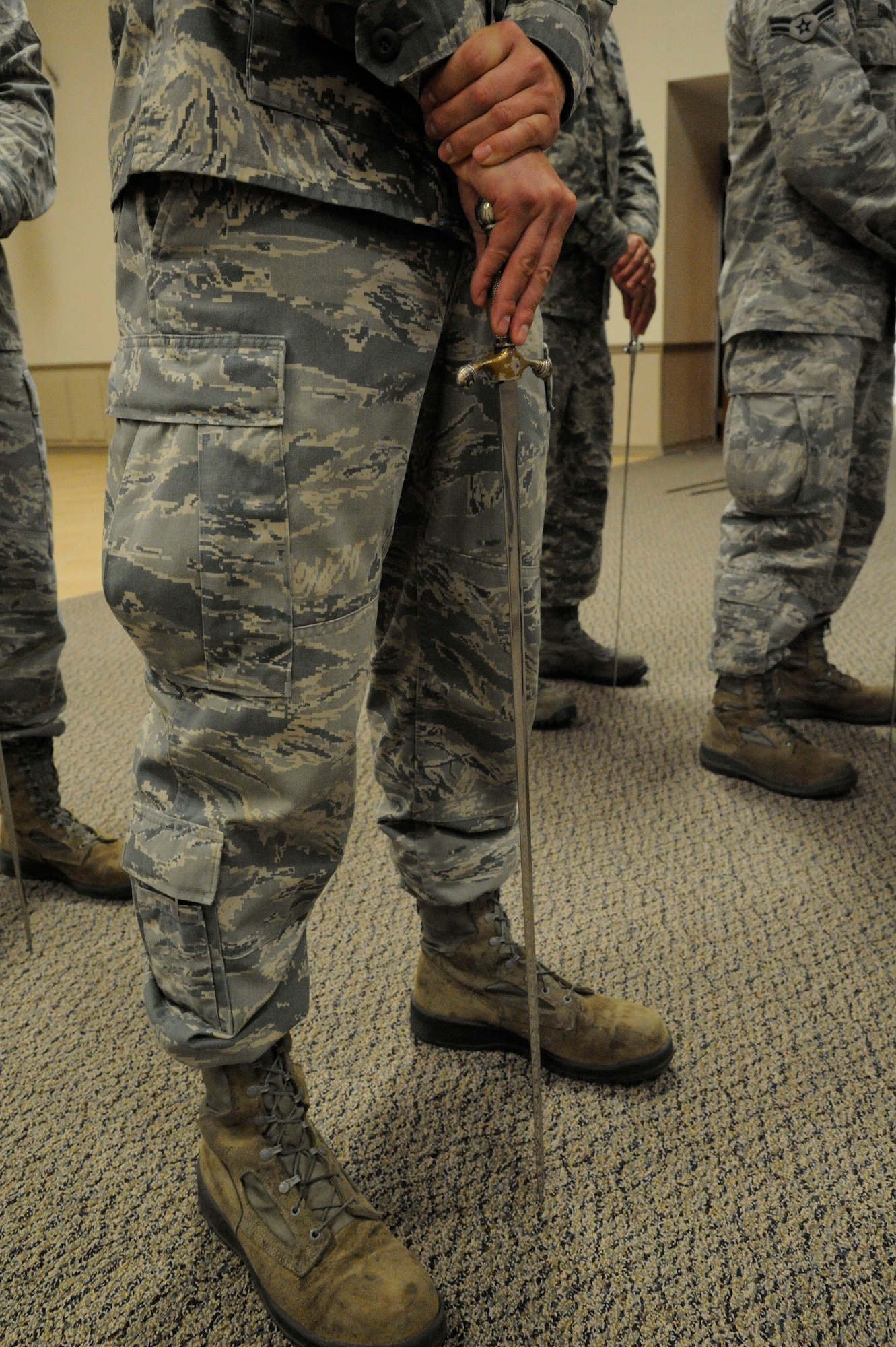 Airmen assigned to the Barksdale Honor Guard Bravo flight stand at ease while practicing a saber cordon on Barksdale Air Force Base, La., April 23, 2013. Airmen walk under a saber cordon during promotion ceremonies to signify the transition of junior Airmen entering the NCO ranks and NCOs entering the senior NCO ranks. It is also used to recognize winners and nominees for awards. (U.S. Air Force photo/Airman 1st Class Andrew Moua)