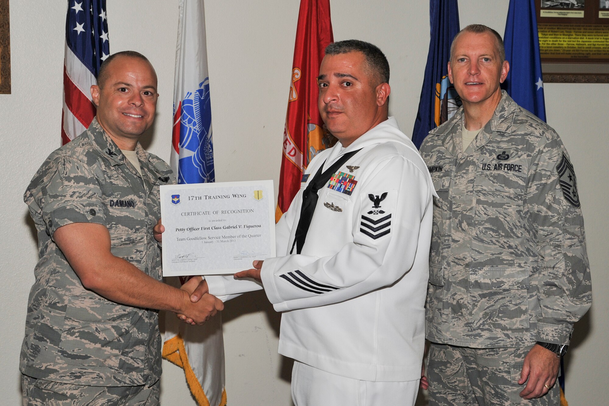 GOODFELLOW AIR FORCE BASE, Texas-- Col. Mark Damiano, 17th Training Wing Commander, and Chief Master Sgt. Scott Lumpkin, 17th TRW Command Chief, present the Team Goodfellow Service member of the Quarter award to Navy Petty Officer 1st Class Gabriel Figueroa, Navy Center for Information Dominance Detachment, during the wing quarterly awards ceremony April 23. (U.S. Air Force photo/Airman 1st Class Michael Smith)