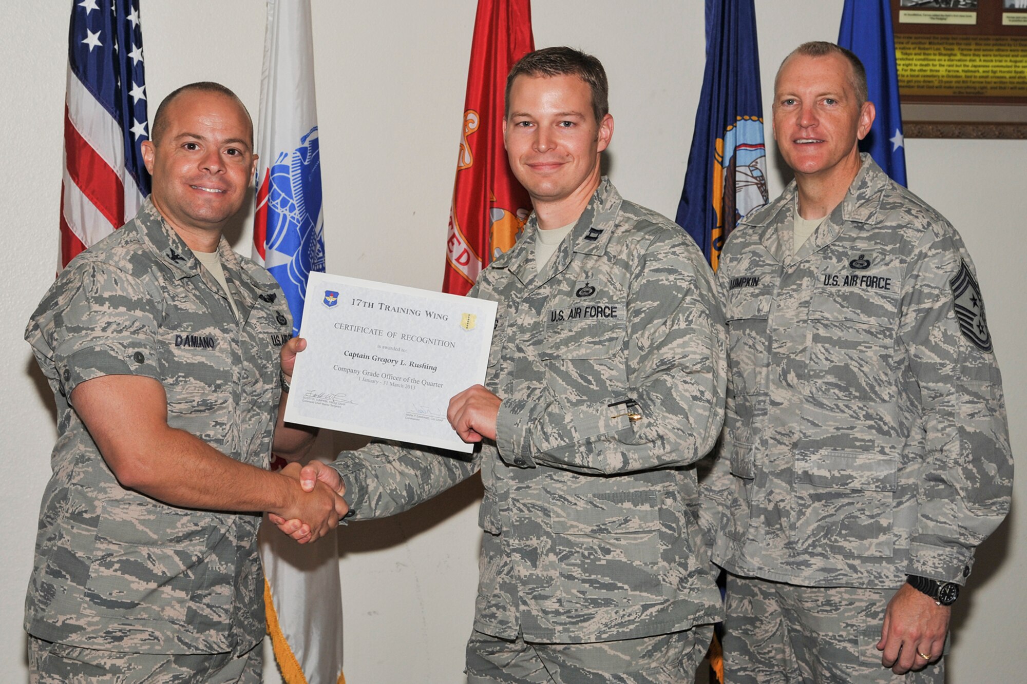 GOODFELLOW AIR FORCE BASE, Texas-- Col. Mark Damiano, 17th Training Wing Commander, and Chief Master Sgt. Scott Lumpkin, 17th TRW Command Chief, present the 17th Training Wing Company Grade Officer of the Quarter award to Capt. Gregory Rushing, 315th Training Squadron, during the wing quarterly awards ceremony April 23. (U.S. Air Force photo/Airman 1st Class Michael Smith)