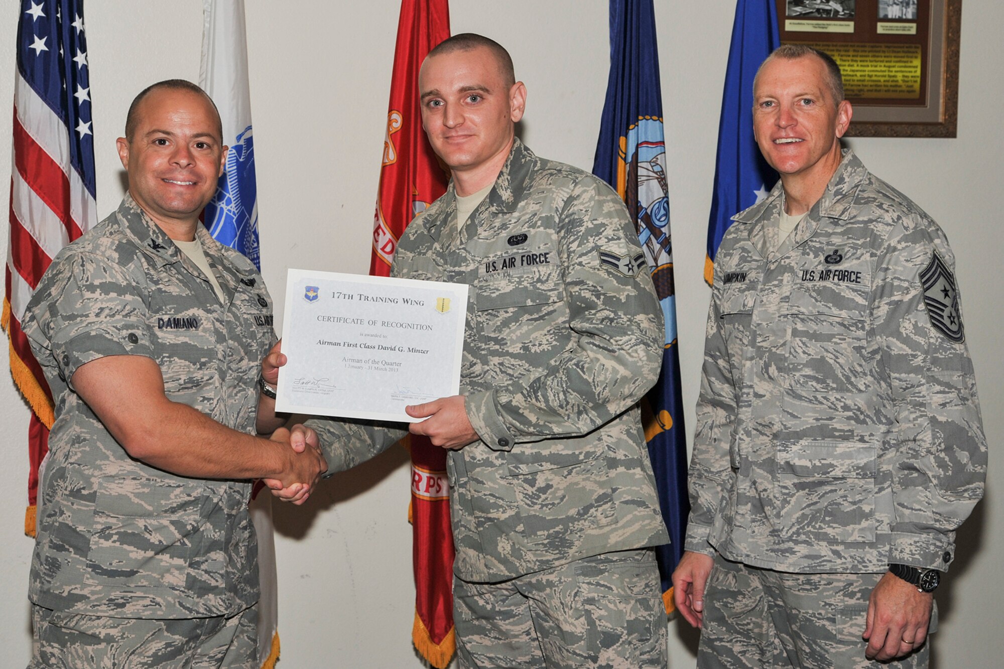 GOODFELLOW AIR FORCE BASE, Texas-- Col. Mark Damiano, 17th Training Wing Commander, and Chief Master Sgt. Scott Lumpkin, 17th TRW Command Chief, present the 17th Training Wing Airman of the Quarter award to Airman 1st Class David Minzer, 17th Communications Squadron, during the wing quarterly awards ceremony  April 23. Minzer also received the Team Goodfellow junior enlisted member of the quarter award. (U.S. Air Force photo/Airman 1st Class Michael Smith)