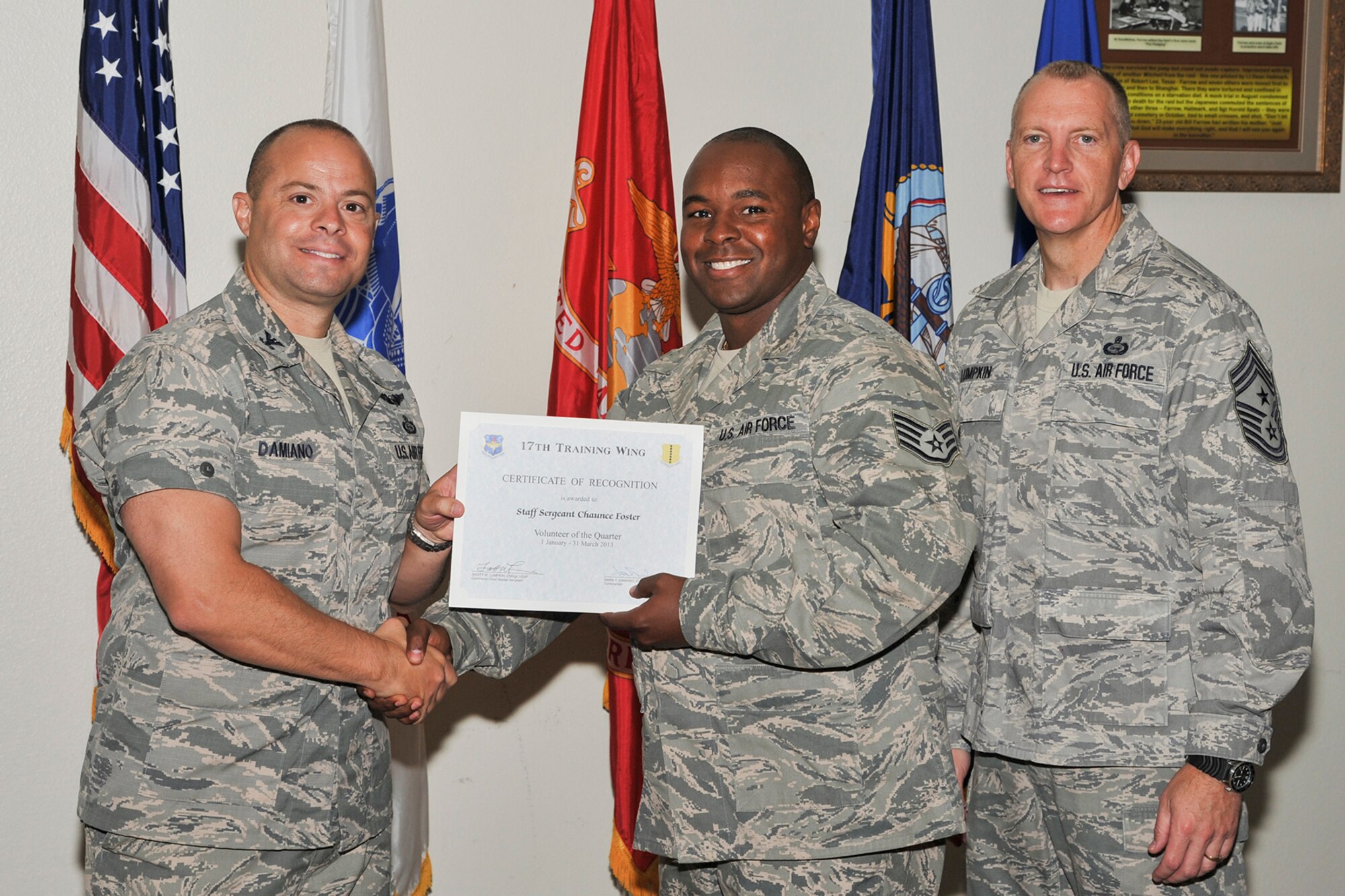 GOODFELLOW AIR FORCE BASE, Texas-- Col. Mark Damiano, 17th Training Wing Commander, and Chief Master Sgt. Scott Lumpkin, 17th TRW Command Chief, present the 17th Training Wing Volunteer of the Quarter to Staff Sgt. Chaunce Foster, 17th Communications Squadron, during the wing quarterly awards ceremony April 23. Foster also received the Team Goodfellow volunteer of the quarter award. (U.S. Air Force photo/Airman 1st Class Michael Smith)