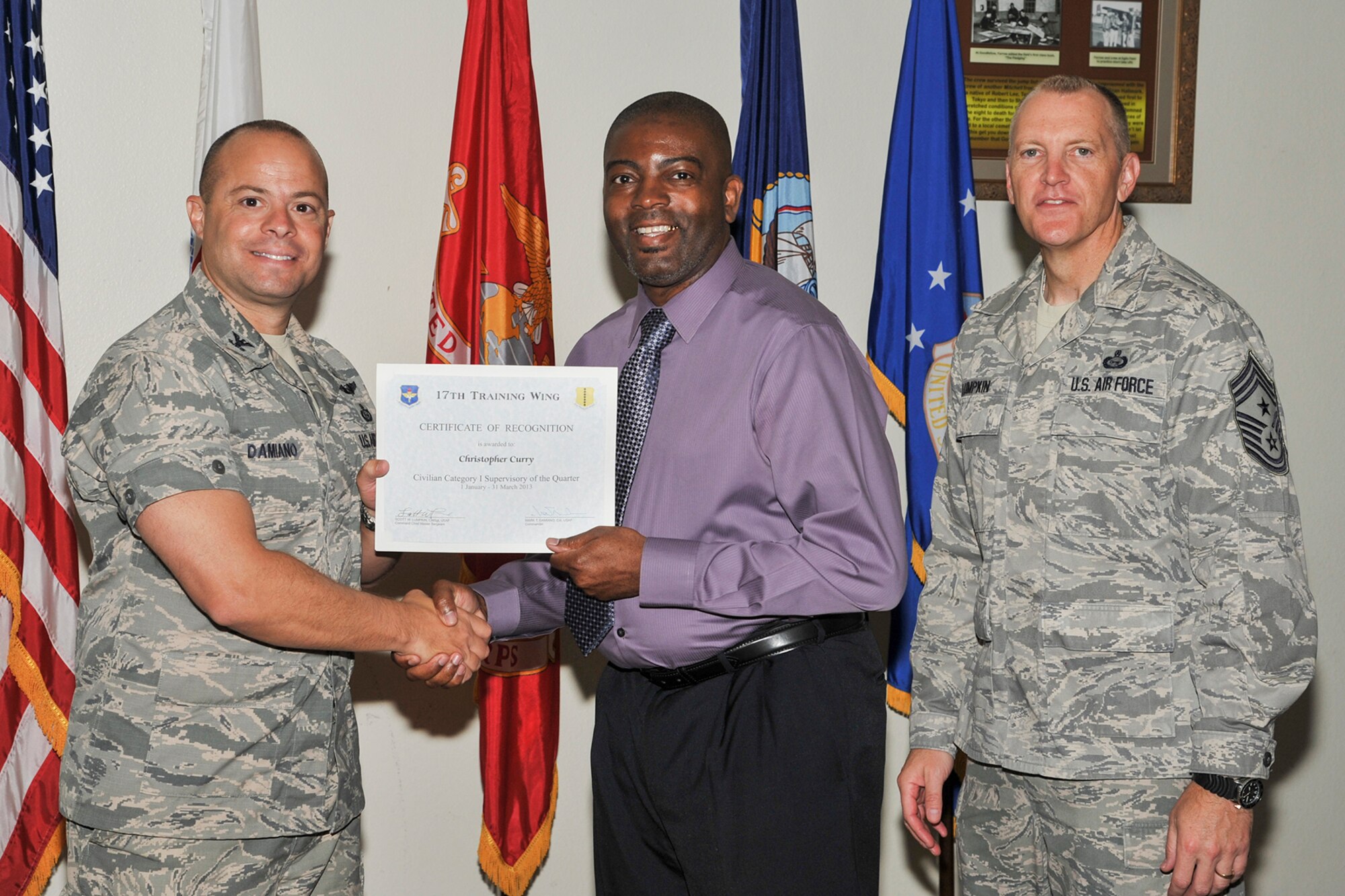 GOODFELLOW AIR FORCE BASE, Texas--  Col. Mark Damiano, 17th Training Wing Commander, and Chief Master Sgt. Scott Lumpkin, 17th TRW Command Chief, present the 17th Training Wing Civilian Supervisor of the Quarter Category I award to Christopher Curry, 17th Logistics Readiness Squadron, during the wing quarterly awards ceremony April 23. (U.S. Air Force photo/ Airman 1st Class Michael Smith)