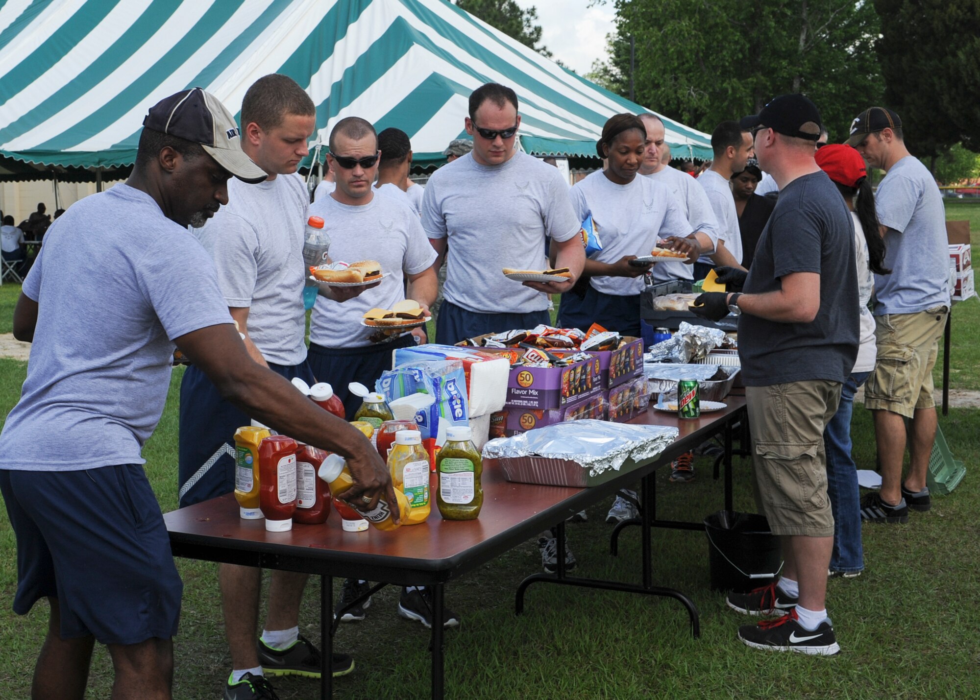 Members of the 23d Maintenance Group have lunch at a cookout for the 23d MXG sports day at Moody Air Force Base, Ga., April 19, 2013. Among the festivities were softball, soccer, tug-of-war and volleyball games. The event was concluded with a 23d MXG leadership tricycle race. (U.S. Air Force photo by Senior Airman Eileen Meier/Released)