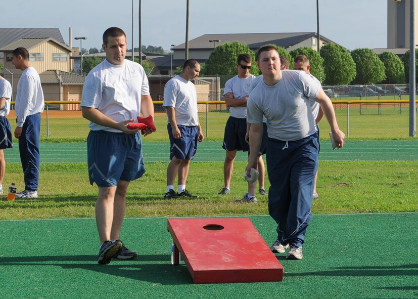 U.S. Air Force Staff Sgt. Loren Worrel and Airman 1st Class Brandon Peters , both from the 723d Aircraft Maintenance Squadron, play a game of bean bag toss during a 23d Maintenance Group sports day event at Moody Air Force Base, Ga., April 19, 2013. Festivities for the day included a cookout, five different sports with championship games and a tricycle race between leadership. (U.S. Air Force photo by Senior Airman Eileen Meier/Released)