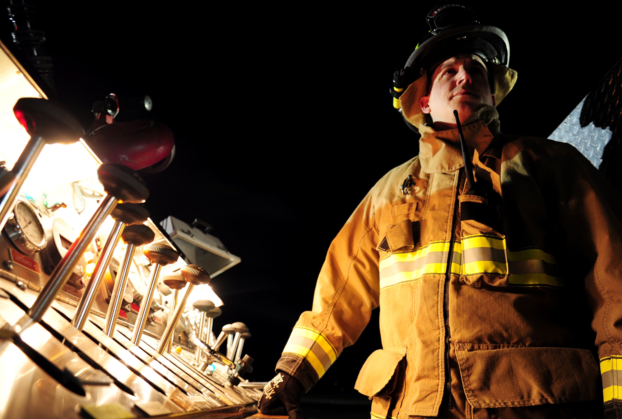 Senior Airman Brentley Everhart, 92nd Civil Engineer Squadron firefighter, operates the pump from one of the fire trucks at Fairchild Air Force Base, Wash., April 17, 2013. Everhart ensures the correct pressure is being flown to the attack lines, guaranteeing effective fire suppression. (U.S. Air Force photo by Airman 1st Class Janelle Patiño/Released)