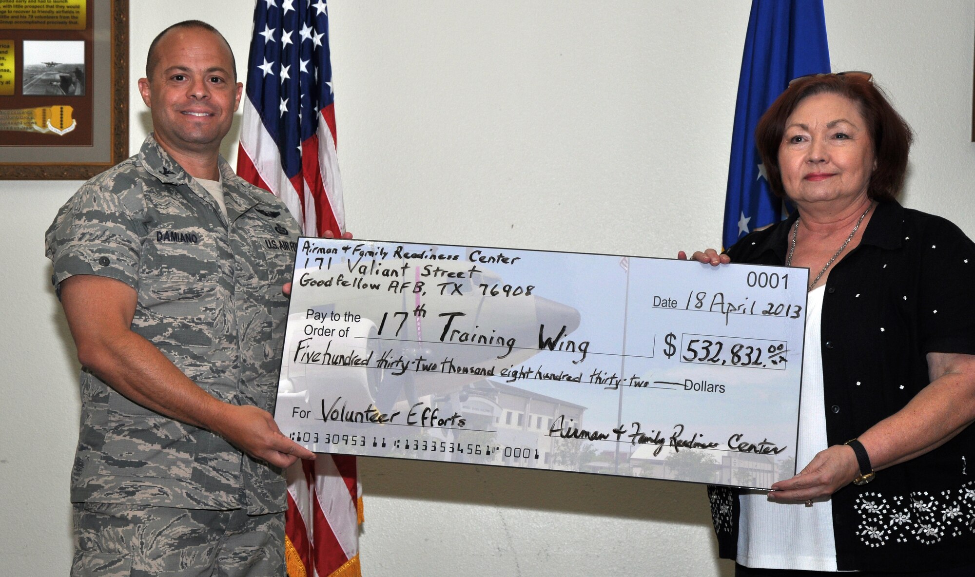 GOODFELLOW AIR FORCE BASE, Texas – Kathy Garrett, Airman and Family Readiness community readiness specialist, presents Col. Mark Damiano, 17th Training Wing Commander, a check at the Event Center here, April 18.   This check represents the $532,832 the volunteers saved the community throughout 2012. (U.S. Air Force photo/ Airman 1st Class Joshua Edwards)