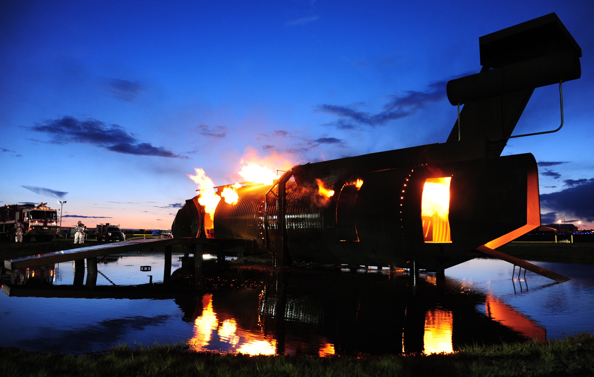The fire department burns an aircraft simulator during live fire training at Fairchild Air Force Base, Wash., April 17, 2013. Col. Biran Newberry, 92nd Air Refueling Wing commander, and his staff took part in the training evolutions to get a first-hand view of the different tasks happening at a crash scene. (U.S. Air Force photo by Airman 1st Class Janelle Patiño/Released)
