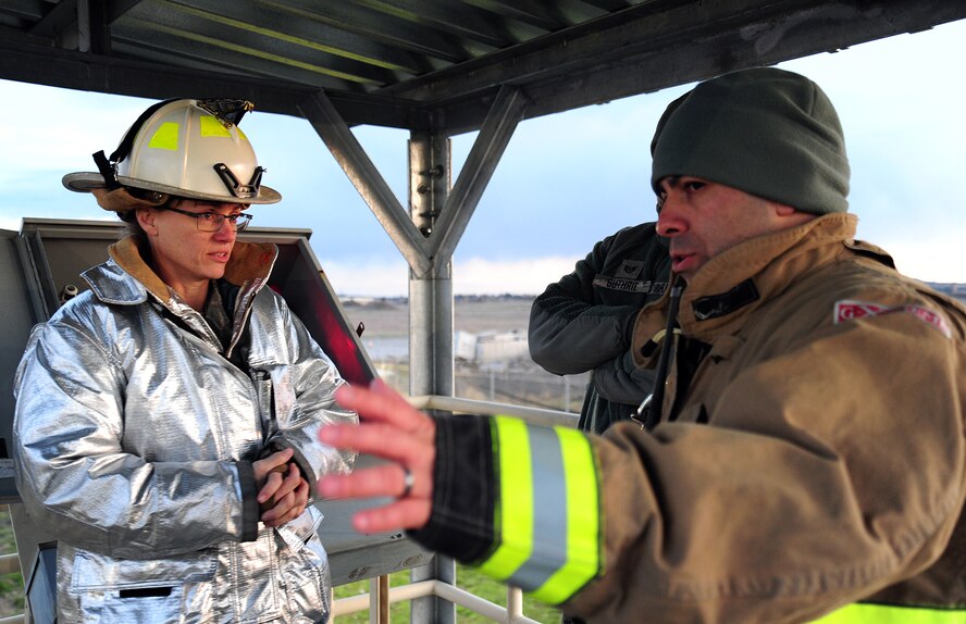 Tech. Sgt. Steevens, 92nd Civil Engineer Squadron fireman, briefs Chief Master Sgt. Wendy Hansen, 92nd Air Refueling Wing command chief, during live fire training at Fairchild Air Force Base, Wash, April 17, 2013. Steevens explains how the assitant chief of operations performs command and control during most major emergencies. (U.S. Air Force photo by Airman 1st Class Janelle Patiño/Released)