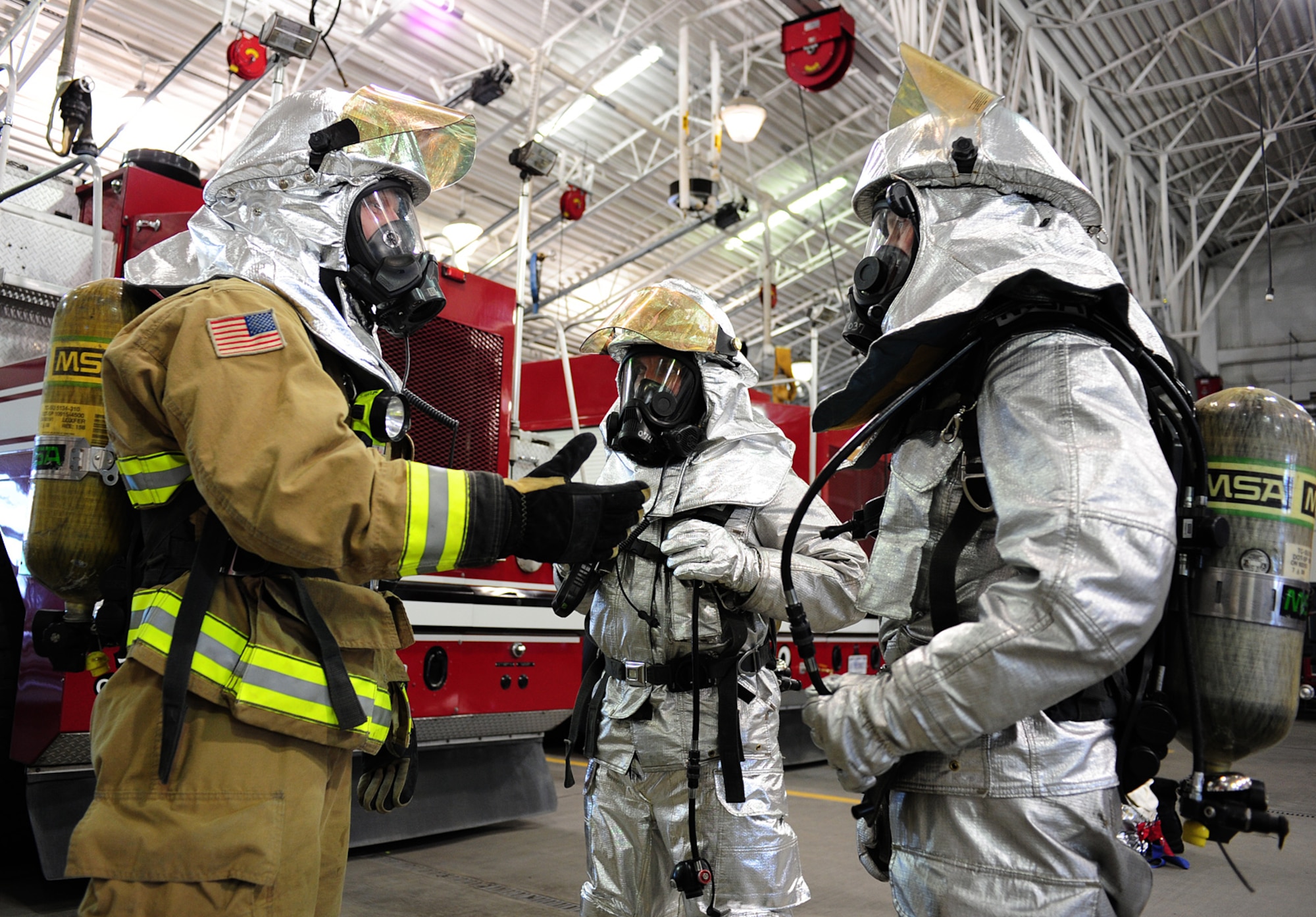 Airman 1st Class Wade Hetland, 92nd Civil Engineer Squadron firefighter, instructs Wing leaders in the proper wear of their personal protective equipment at Fairchild Air Force Base, Wash., April 17, 2013. Hetland highlights the importance of team work while performing buddy checks, as any exposed skin could suffer from heat and/or steam burns during live fire training. (U.S. Air Force photo by Airman 1st Class Janelle Patiño/Released)