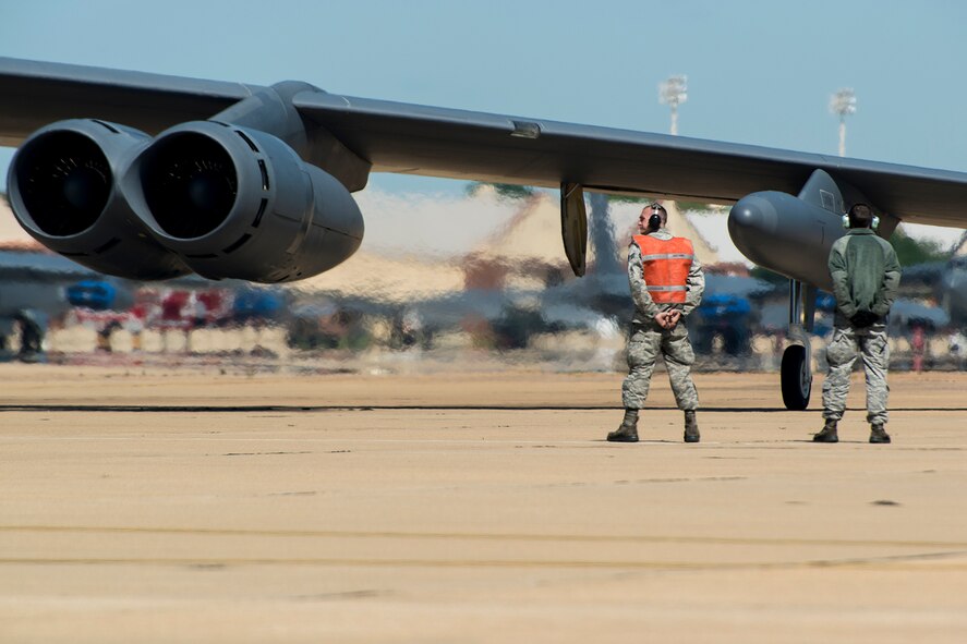 U.S. Air Force Senior Airman Lucas Guthrie and Airman 1st Class Jacob Ranum, 2nd Aircraft Maintenance Squadron crew chiefs, prepare to marshal a B-52H Stratofortress prior to a sortie, April 19, 2013, Barksdale Air Force Base, La. The aircraft is participating in a nuclear exercise at Minot AFB, N.D., and is piloted by aircrew assigned to the 343rd Bomb Squadron at Barksdale. (U.S. Air Force photo by Master Sgt. Greg Steele/Released)
