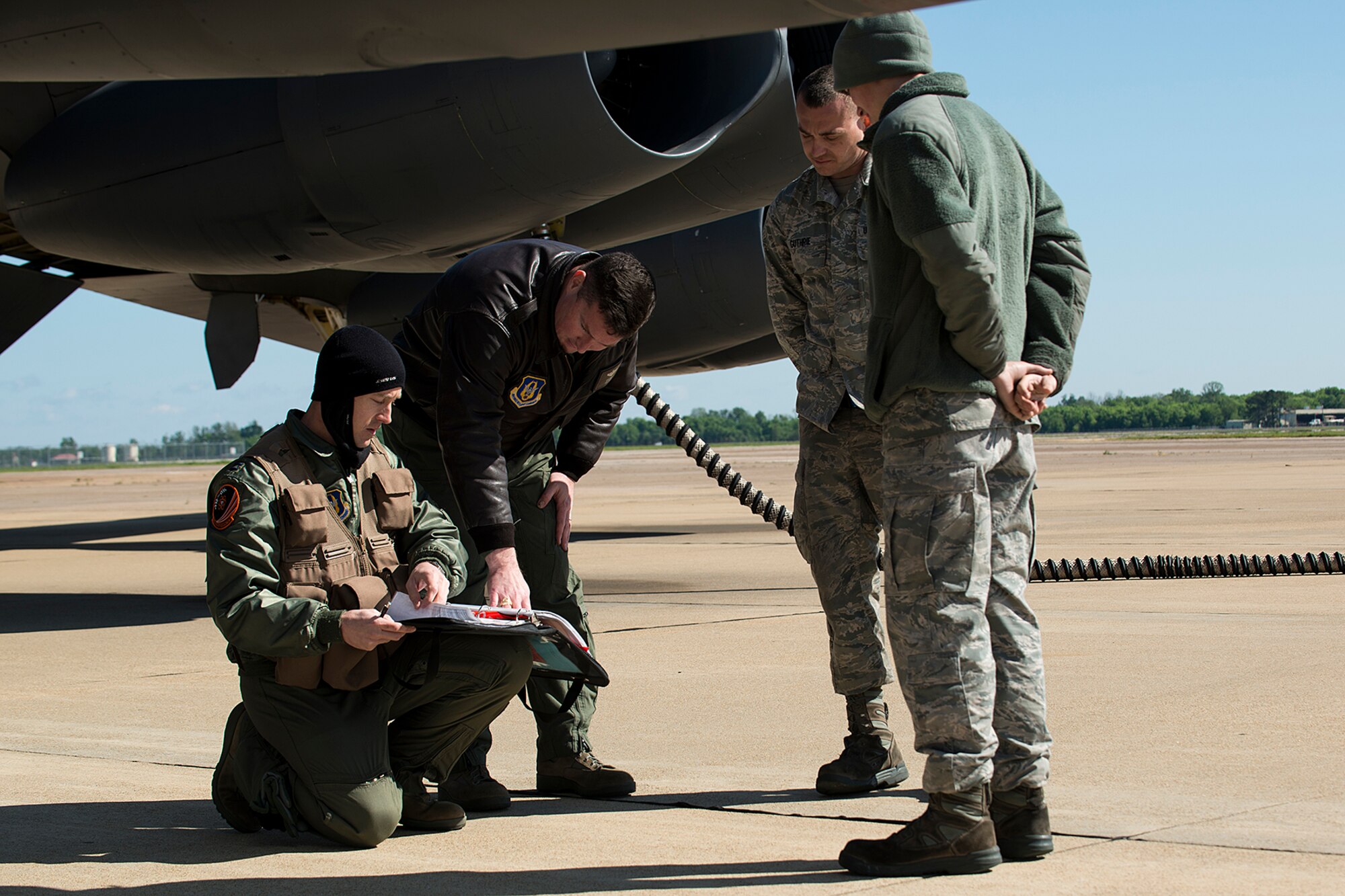 U.S. Air Force Capt. Christ Robinson, kneeling, and Capt. Drew Baird, look over the aircraft forms of a 2nd Bomb Wing B-52H Stratofortress prior to a sortie, April 19, 2013, Barksdale Air Force Base, La. Robinson and Baird are assigned to the 343rd Bomb Squadron and are flying to Minot AFB, N.D., to be a part of a nuclear exercise. (U.S. Air Force photo by Master Sgt. Greg Steele/Released)