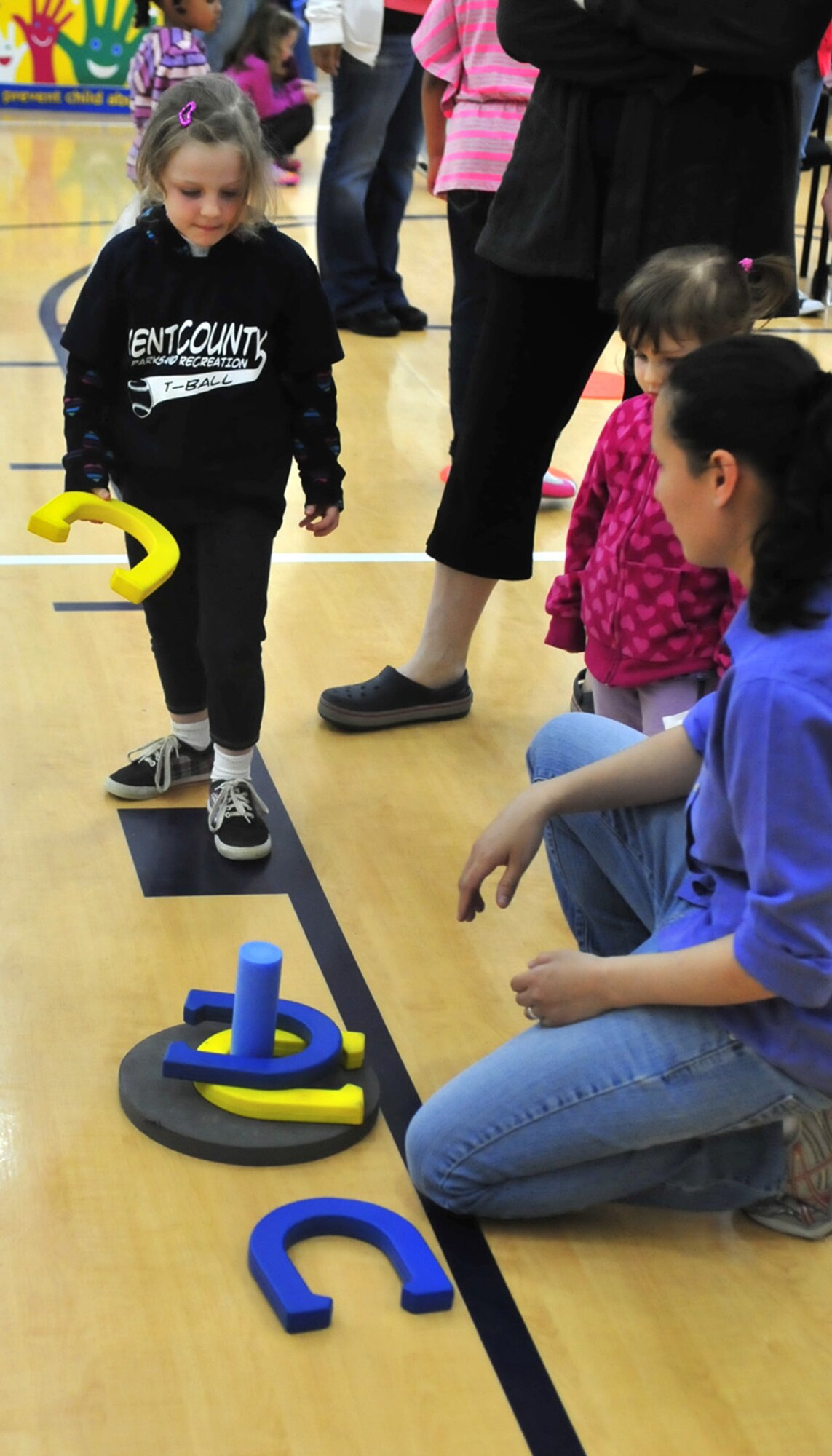 Layna Hoeber tosses a horse shoe toward the ring April 20, 2013, at the youth center on Dover Air Force Base, Del. The youth center hosted a carnival to celebrate the Month of the Military Child. (U.S. Air Force photo/Tech. Sgt. Chuck Walker)
