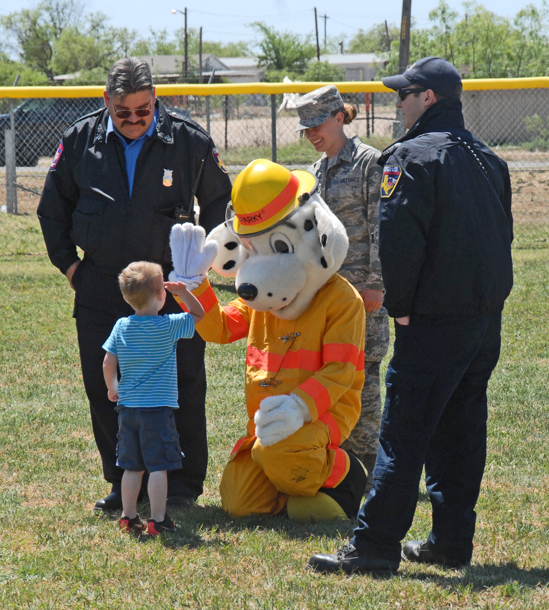 GOODFELLOW AIR FORCE BASE, Texas—A youth high-five’s Sparky the Fire Dog during Children’s Fest, at the Youth Center baseball field, here, April 20. Children’s Fest brings Goodfellow families together for an activity-filled afternoon. (U.S. Air Force photo/1st Lt. Leanne Hedgepeth)