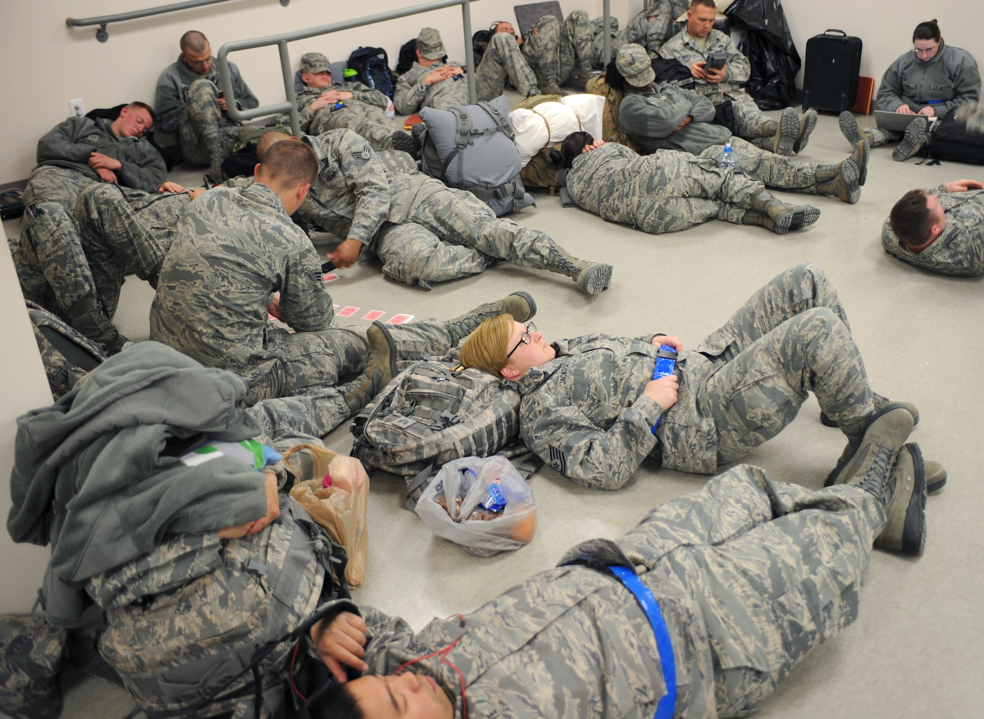 U.S. Air Force Airmen from the 366th Fighter Wing rest and relax while waiting to board the plane before their deployment April 23, 2013, at Mountain Home Air Force Base, Idaho.  The Mountain Home Airmen will support F-15E overseas contingency missions designed to deliver combat air power for joint operations and to meet ground commander requirements. (U.S. Air Force photo by Senior Airman Benjamin Sutton/Released)