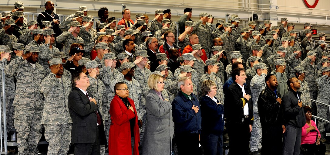 Service members salute as civilian attendants hold their hands over their hearts during the playing of the National Anthem for the 633rd Air Base Wing change of command ceremony at Langley Air Force Base, Va., April 22, 2013. U.S. Air Force Col. John J. Allen succeeds Col. Korvin Auch as commander of the wing. (U.S. Air Force photo by Airman 1st Class Kimberly Nagle/Released)