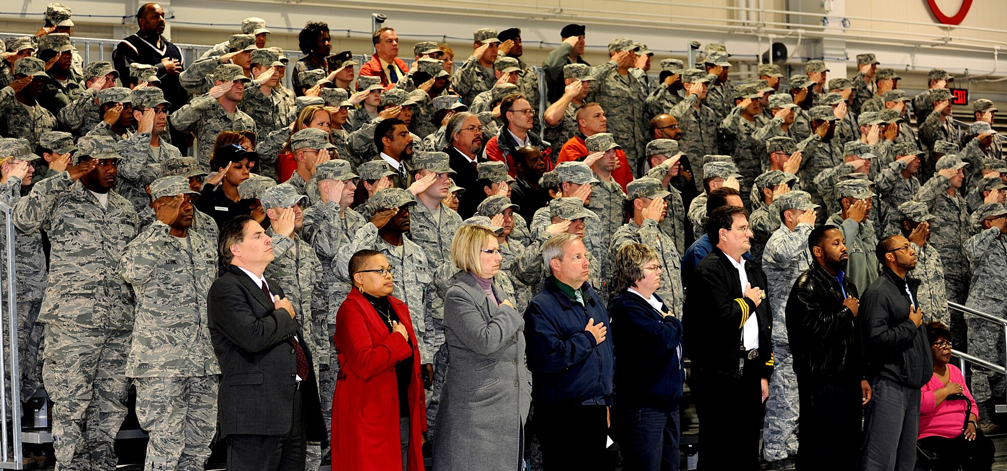 Service members salute as civilian attendants hold their hands over their hearts during the playing of the National Anthem for the 633rd Air Base Wing change of command ceremony at Langley Air Force Base, Va., April 22, 2013. U.S. Air Force Col. John J. Allen succeeds Col. Korvin Auch as commander of the wing. (U.S. Air Force photo by Airman 1st Class Kimberly Nagle/Released)
