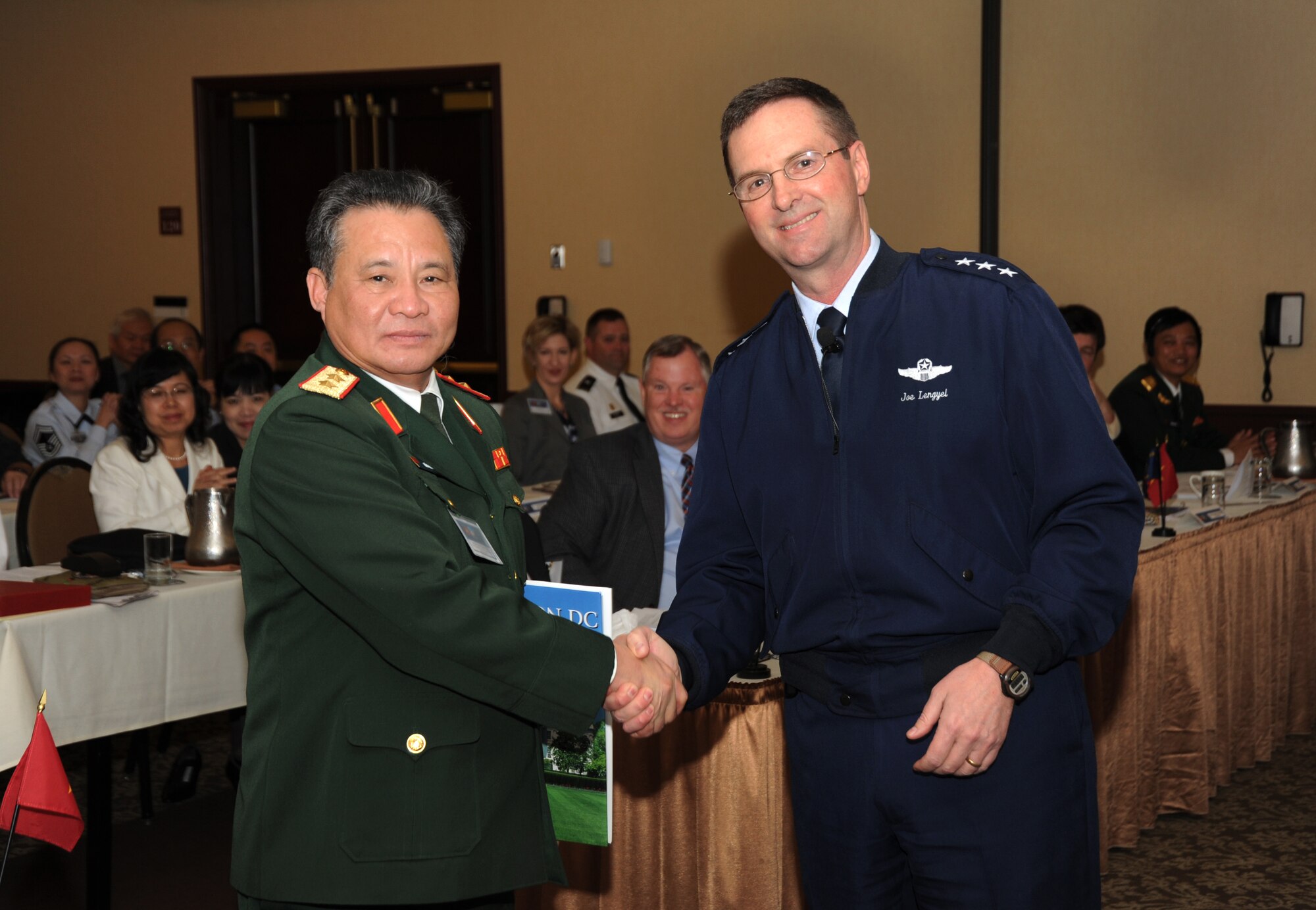 U.S. Air Force Lt. Gen. Joseph L. Lengyel (right), Vice Chief, National Guard Bureau, gives a book as a gift to Lt. Gen. Tran Quang Khue (left), Deputy Chief of General Staff of the Vietnam People's Army, following Lengyel's speech at the State Partnership Program Workshop held in Portland, Ore., April 19. Khue led a Vietnam delegation which visited Oregon National Guard facilities as part of the ongoing partnership between the Oregon National Guard and Vietnam, made official in November 2012. The National Guard Bureau program pairs emerging democracies with National Guard states. (Air National Guard photo by Air Force Tech. Sgt. John Hughel, 142nd Fighter Wing Public Affairs)