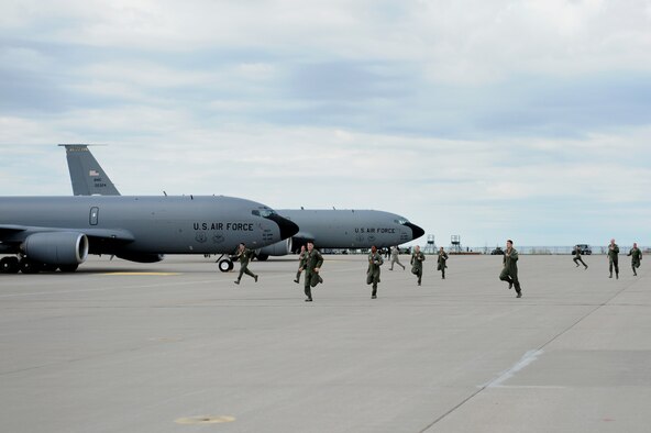 Aircrew members sprint to their aircraft April 14, 2013, McConnell Air Force Base, Kan. During the recent nuclear operational readiness inspection, Team McConnell operated around the clock April 12 to 16, to showcase the wing’s ability to function at a moment’s notice. (U.S. Air Force Photo/2nd Lt. Jessica Brown)