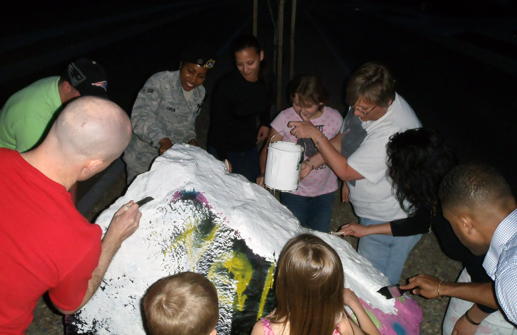 Tracey Spencer, top right, the Sexual Assault Response Coordinator at Holloman Air Force Base, N.M., pours paint over the rock at the commanders’ circle April 13. Victim advocates and their families painted the rock in honor of Sexual Assault Awareness Month. To report a sexual assault, call the 27/7 sexual assault response hotline at (575) 572-6789. (U.S. Air Force photo by Staff Sgt. Carolyn Herrick/Released) 