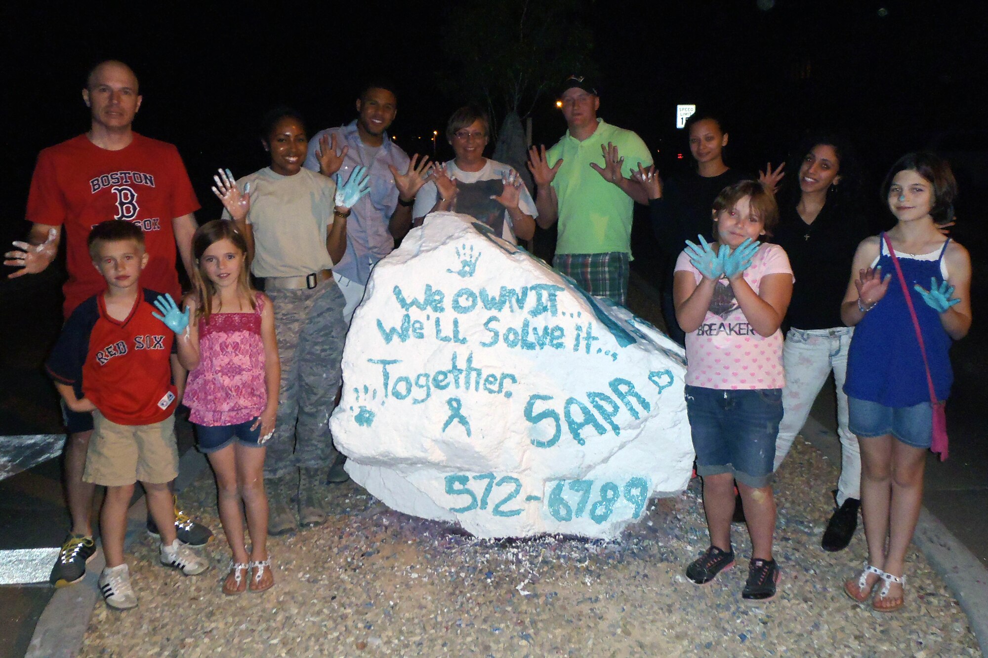 Victim advocates pose for a photo after painting the rock at the commanders’ circle at Holloman Air Force Base, N.M., April 13. April is Sexual Assault Awareness Month. To report a sexual assault, call the 27/7 sexual assault response hotline at (575) 572-6789. (U.S. Air Force photo by Staff Sgt. Carolyn Herrick/Released)