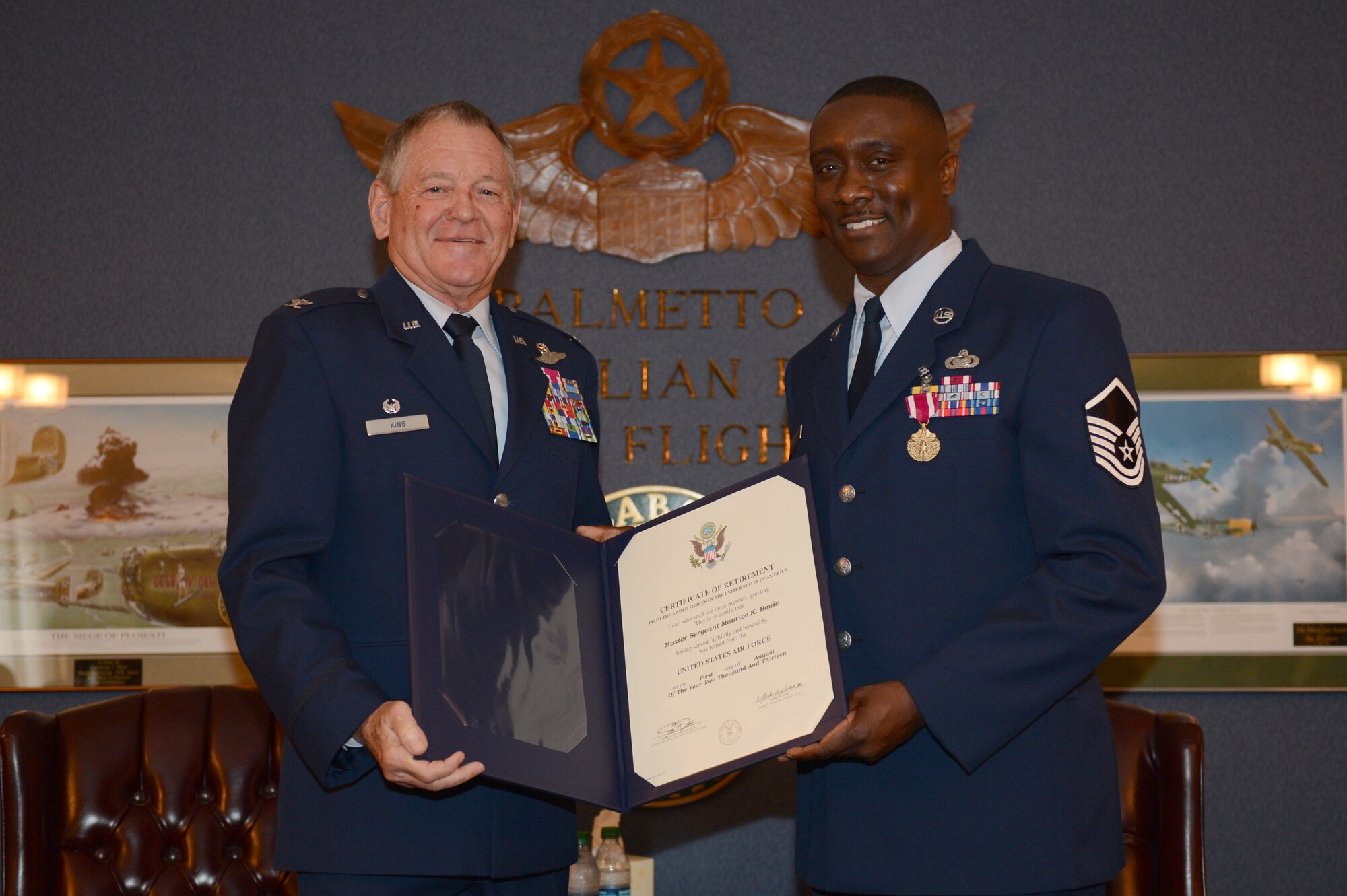 Retired Col. Thomas King presents Master Sgt. Karl Bouie, 482nd Operations Group Detachment 1, Commander Support Staff NCO in charge, with his certificate of retirement, April 12, 2013. Bouie has served in the U.S. Air Force for 27 years. (U.S. Air Force photo by Airman 1st Class Krystal M. Jeffers/Released)