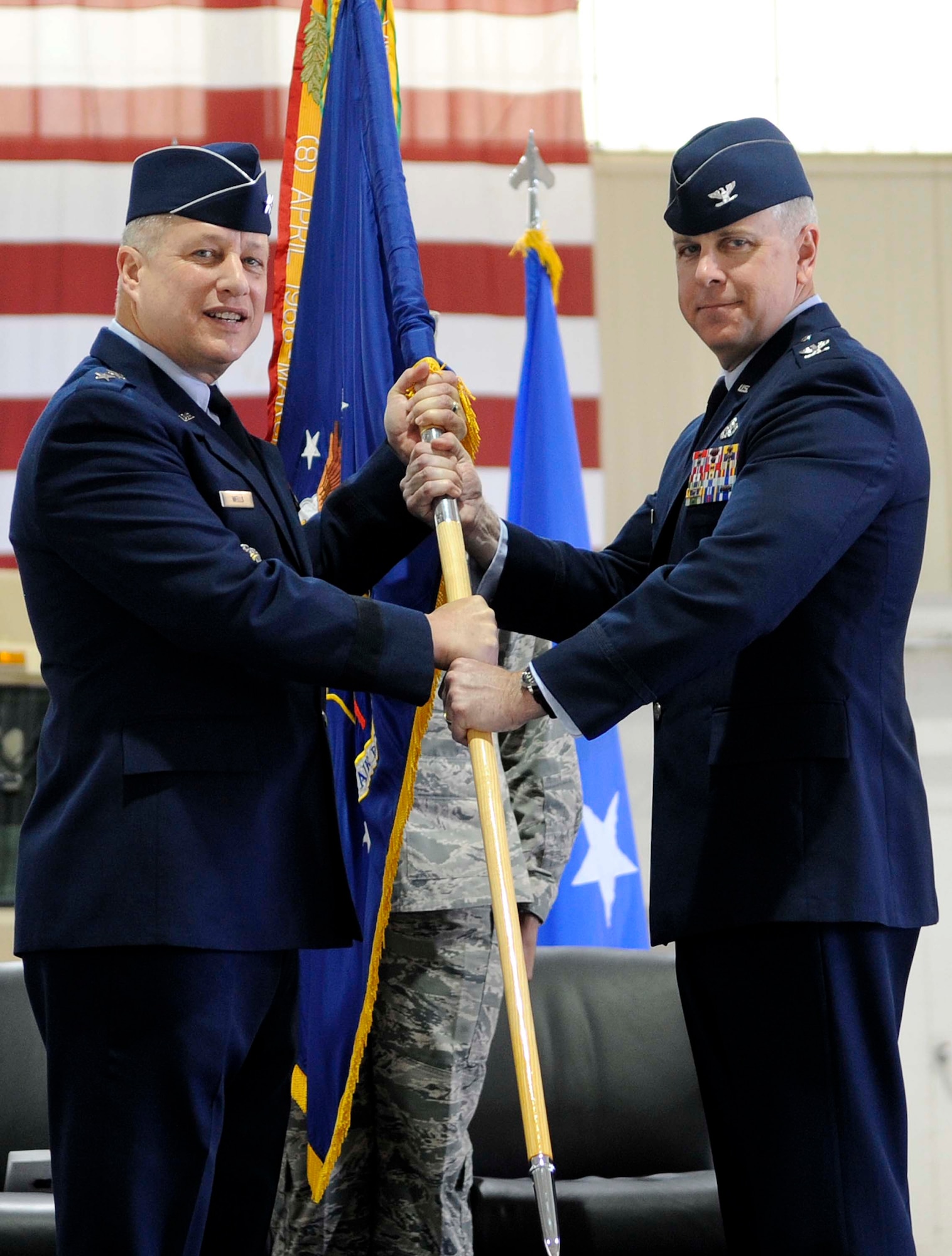 Maj. Gen. Lawrence Wells, 9th Air Force commander, passes the guidon to Col. John J. Allen Jr., the newly appointed 633rd Air Base Wing commander, during the 633rd change of command ceremony at Langley Air Force Base, Va., April 22, 2013. Allen assumed command of the wing from Col. Korvin D. Auch. (U.S. Air Force photo by Staff Sgt. Dana Hill/Released)