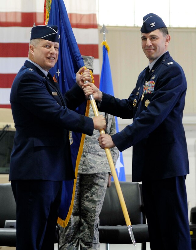 Maj. Gen. Lawrence Wells, 9th Air Force commander, receives the 633rd Air Base Wing guidon from Col. Korvin D. Auch during the change of command ceremony at Langley Air Force Base, Va., April 22, 2013. Auch relinquished command to Col. John J. Allen Jr. (U.S. Air Force photo by Staff Sgt. Dana Hill/Released)