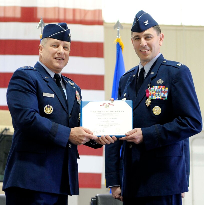 Maj. Gen. Lawrence Wells, 9th Air Force commander, presents Col. Korvin D. Auch with the Legion of Merit medal during the 633rd Air Base Wing change of command ceremony at Langley Air Force Base, Va., April 22, 2013. During his time as commander, Auch supported a number of unique missions at Joint Base Langley-Eustis. (U.S. Air Force photo by Staff Sgt. Dana Hill/Released)