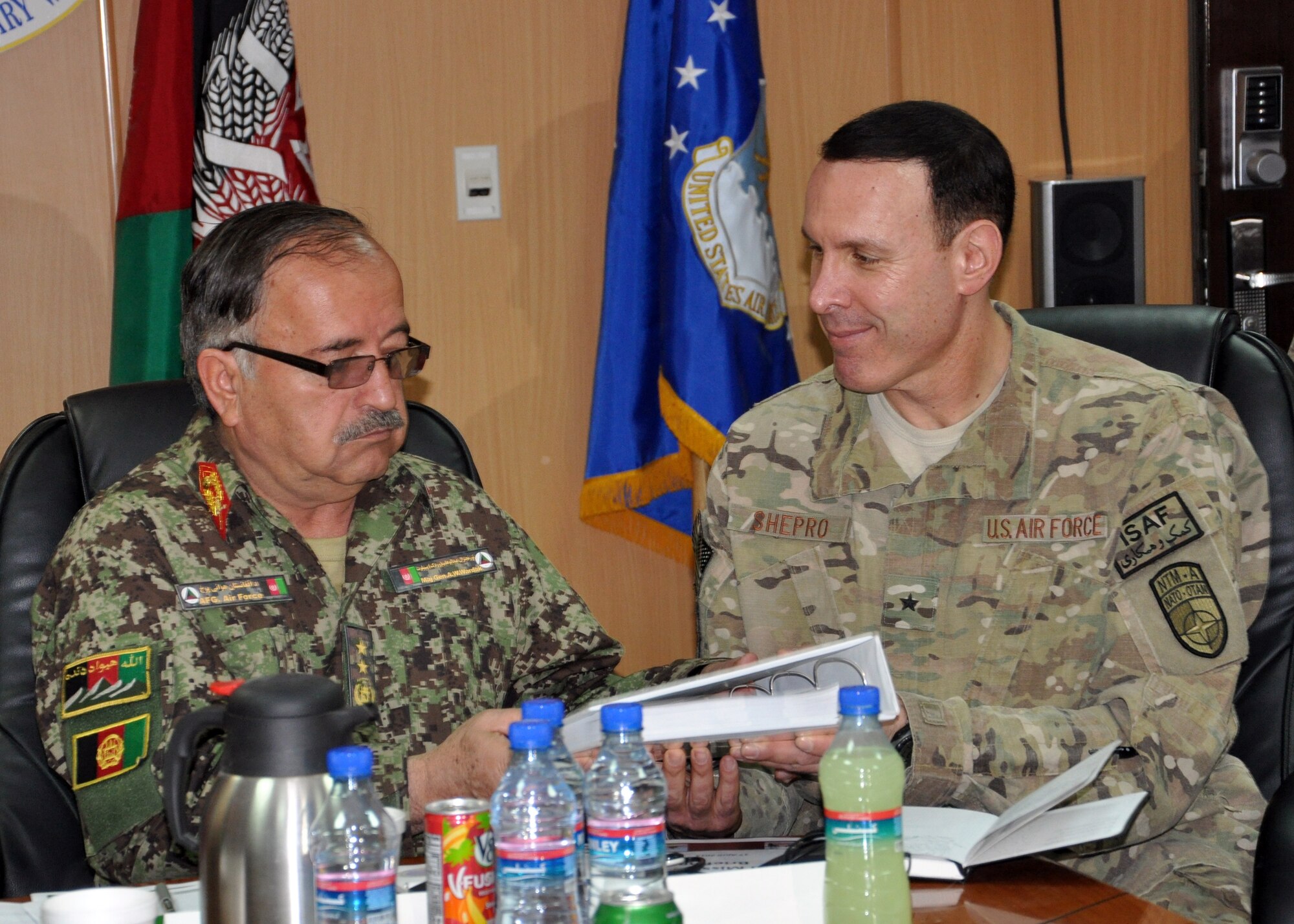 KABUL, AFGHANISTAN– In a ceremony held at the NATO Air Training Command-Afghanistan headquarters, Brig. Gen. Steven Shepro, NATC-A commander, hands Maj. Gen. Abdul Wahab Wardak, Afghan Air Force commander, a copy of the finalized Afghan Air Force Military Occupation Specifications Additional Skills Identification Guide April 17, 2013. (U.S. Air Force photo/Capt. Anastasia Wasem)