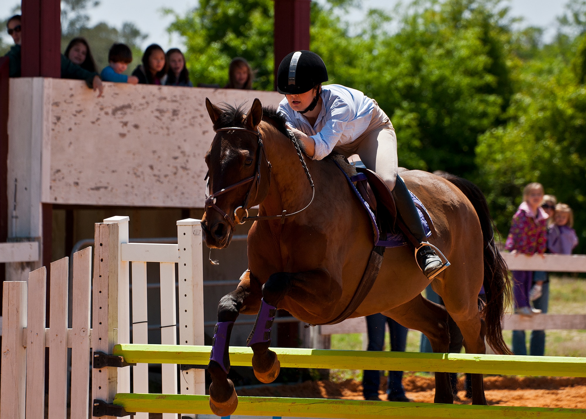 Wren SanClemente and her horse jump over a barrier during a jumping demonstration at the Sand and Spur Riding Club open house event April 20 at Eglin Air Force Base, Fla.  The club provided pony rides for kids and riding and training demonstrations. Those who attended got an up close and hands-on experience with many of the different breeds of horses housed at the stables on base.  (U.S. Air Force photo/Samuel King Jr.)