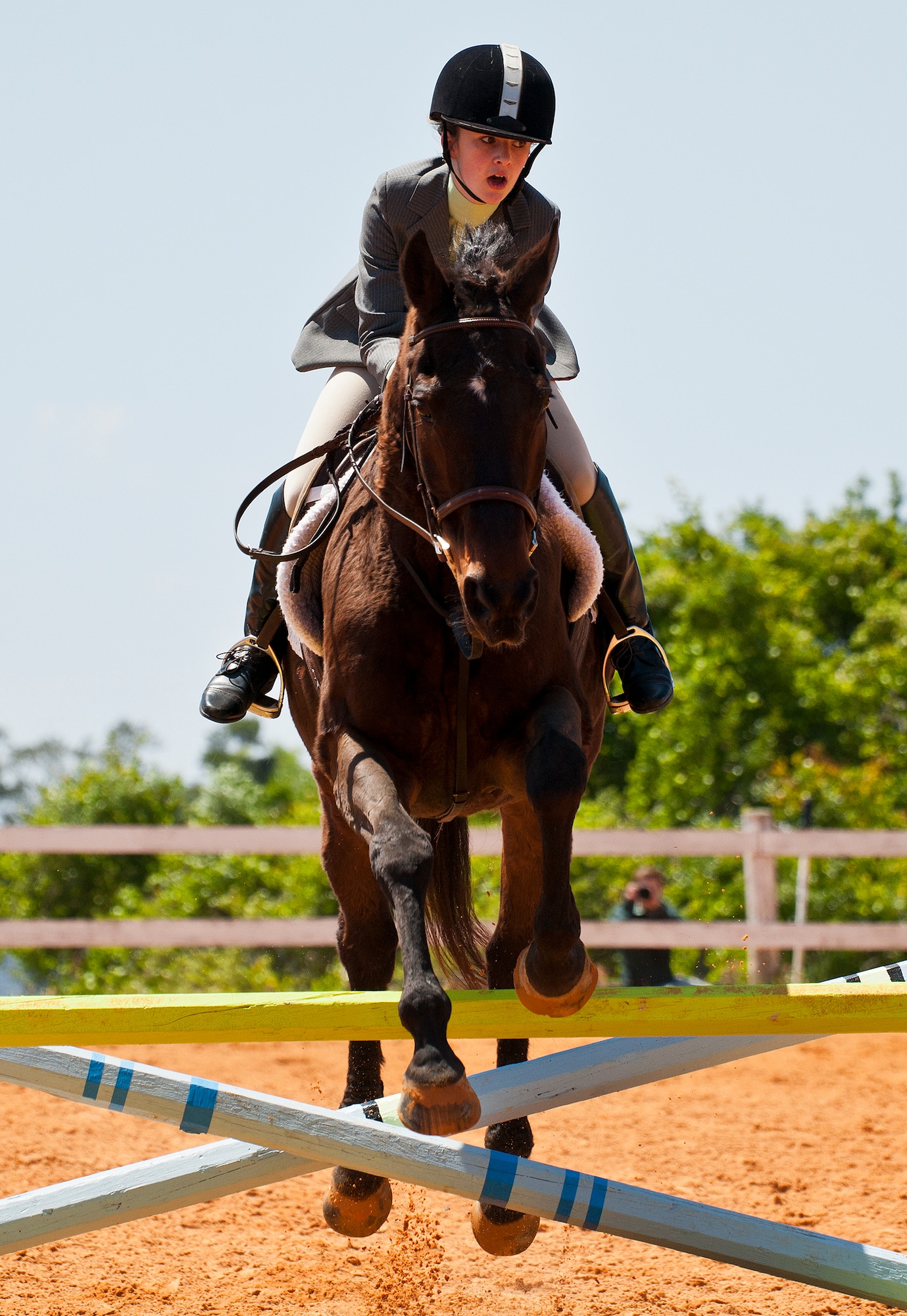 Ellie SanClemente and her horse jump over a barrier during a jumping demonstration at the Sand and Spur Riding Club open house event April 20 at Eglin Air Force Base, Fla.  The club provided pony rides for kids and riding and training demonstrations. Those who attended got an up close and hands-on experience with many of the different breeds of horses housed at the stables on base.  (U.S. Air Force photo/Samuel King Jr.)