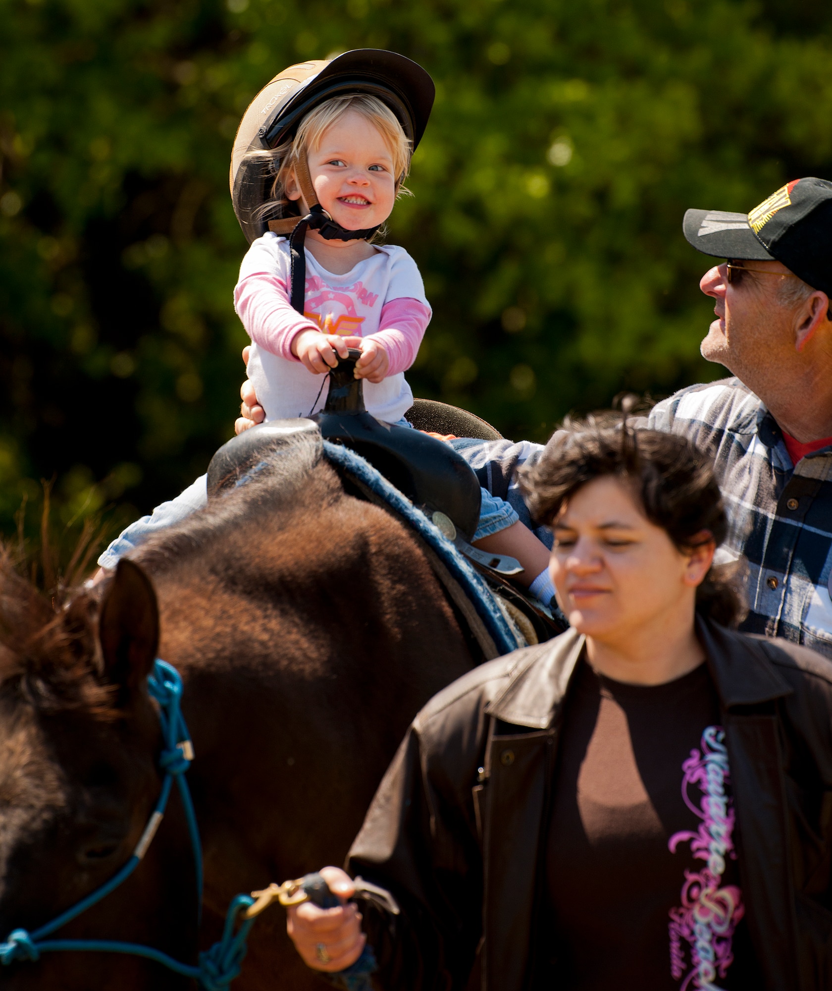 An attendee enjoys her first pony ride at the Sand and Spur Riding Club open house event April 20 at Eglin Air Force Base, Fla.  The club provided pony rides for kids and riding and training demonstrations. Those who attended got an up close and hands-on experience with many of the different breeds of horses housed at the stables on base.  (U.S. Air Force photo/Samuel King Jr.)