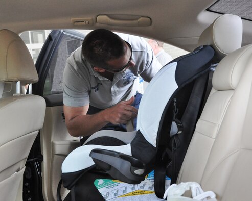 Panama City Beach Fire Rescue firefighter and emergency management technician, Mr. Tim Smith, installed a new car seat in 601st Air and Space Operations Center command and control planner, Tech. Sgt. Marquis Bell’s, vehicle April 19 at The Heritage Club overhang. This is year’s event was to support Child Abuse Awareness and Prevention Month. The child car seat safety program is part of the PCB Fire Rescue’s Emerald Coast Safe Kids Chapter, which helps educate people about child car seat safety along with other safety advice. (U.S. Air Force photo by 2nd Lt. Andrea Valencia)