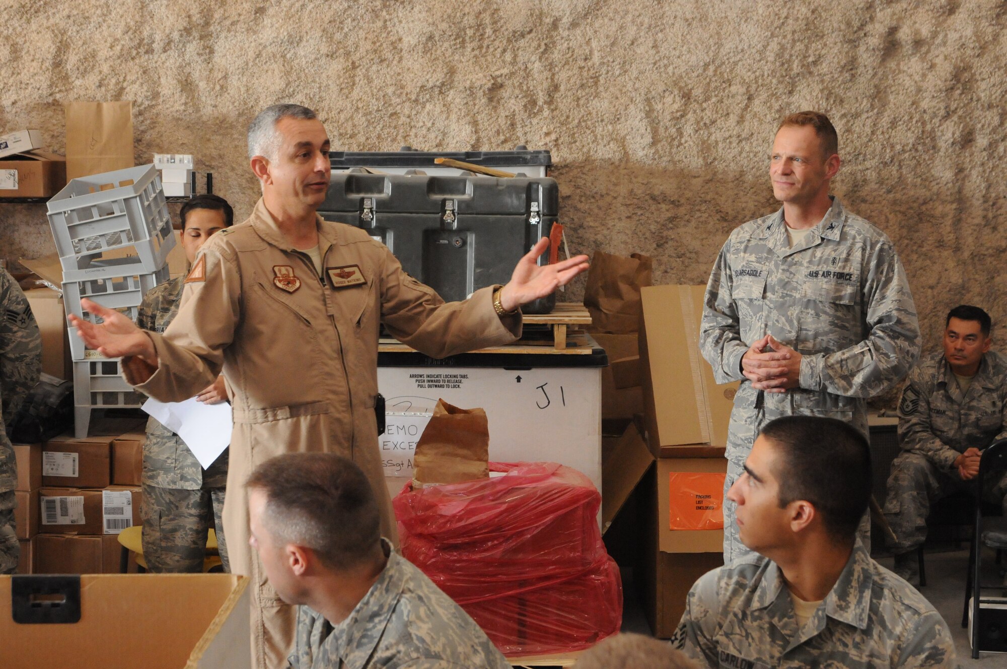 SOUTHWEST ASIA -- Brig. Gen. Roger Watkins, 379th Air Expeditionary Wing commander, and Col. James Clapsaddle, 379th Expeditionary Medical Group commander, welcome 33 volunteers who crowded into the 379th EMDG Medical Logistics Warehouse for four hours April 19. They recertified up to 1,500 individual first aid kits used by forward operating bases of all services across the U.S. Central Command's area of responsibility. These missions are held monthly by the 379th EMDG, one of only two locations in the AOR capable of recertifying IFAKs. (U.S. Air Force photo/Master Sgt. Christian Michael)