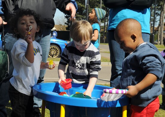 Team Mildenhall children play at an Educational and Developmental Intervention Services bubble station during the RAF Mildenhall Child Development Center and Airmen and Family Readiness Center Spring Fest and Child Find event April 20, 2013, at RAF Mildenhall, England. Staff from EDIS gave out bubbles and had two tables dedicated to look for various developmental skills and milestones. The activity showed parents how their children are developing fine-finger dexterity skills by blowing and popping bubbles and their motor development as they run and chase the bubbles in the wind. (U.S. Air Force photos by Staff Sgt. Tabitha M. Lee/Released)