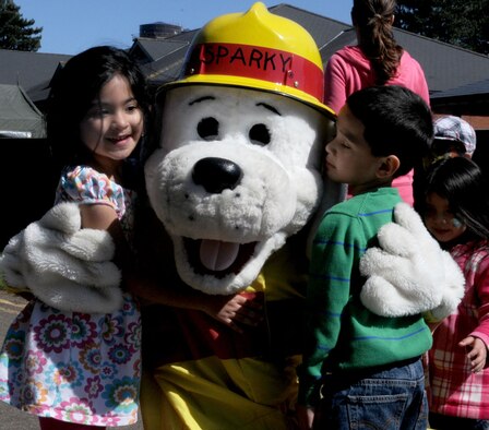 RAF Mildenhall children greet Sparky the Fire Dog, 100th Civil Engineer Squadron mascot, during the RAF Mildenhall Child Development Center and Airmen and Family Readiness Center Spring Fest and Child Find event April 20, 2013, at RAF Mildenhall, England. The event offered fun and games for all ages, and giving families an opportunity to relax and enjoy the spring weather. (U.S. Air Force photos by Staff Sgt. Tabitha M. Lee/Released)
