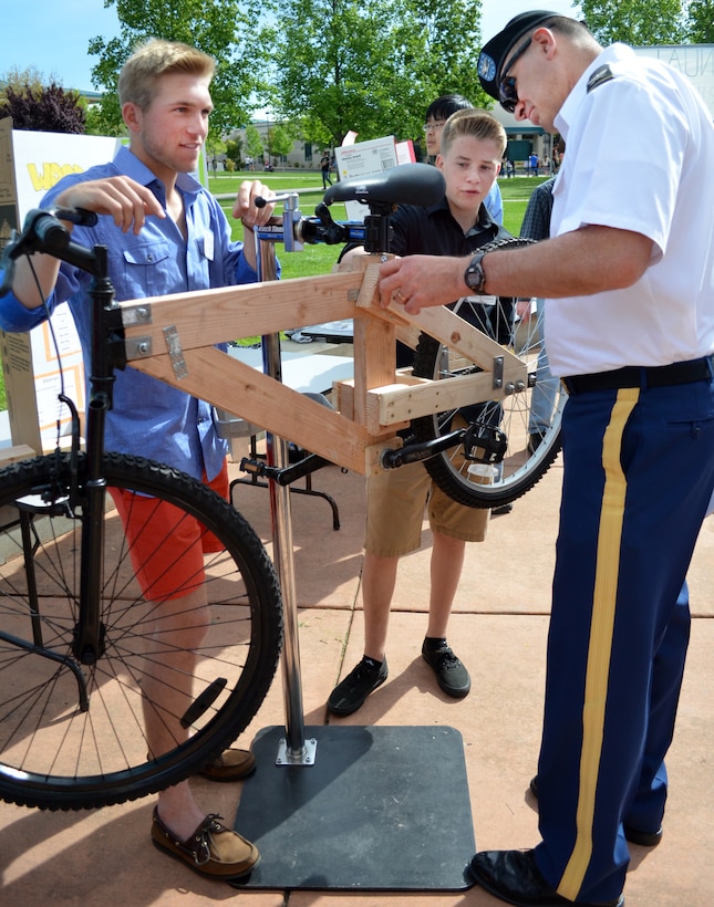 Col. Bill Leady, commander of the U.S. Army Corps of Engineers Sacramento District, discusses a wooden bike with the students who assembled it for competition in the sixth annual Folsom High School Engineering Challenge in Folsom, Calif, April 19, 2013. A half dozen personnel from the U.S. Army Corps of Engineers Sacramento District took part as judges for the event that promotes careers in science, technology, engineering and math. Photo cropped for emphasis. (U.S. Army photo by Robert Kidd/Released