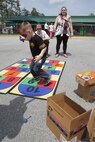 A Marine teaches his child how to play hopscotch to celebrate the Month of the Military Child during a block party at the Child Development Center aboard Marine Corps Air Station New River, April 13. The Children, Youth and Teen Program hosted the party to inform the children about what their parents do aboard the air station.
