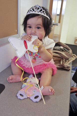 Arianna, 6-month old, chews on a fairy want during the 'Once Upon a Time' story time at the Marine Corps Air Station New River library, April 16. During the story time, children watched as library staff read and re-enacted the story in the book. 
