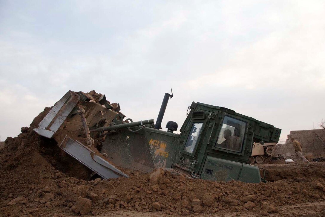 A U.S. Marine Corps bulldozer assigned to Engineer Support Company, 2nd Combat Engineer Battalion (CEB) clears a disposal pit at village stability platform (VSP) Shurakay, Helmand province, Afghanistan, Feb. 17, 2013. The Marines of 2nd CEB were supporting Operation Dynamic Partnership, a multi-unit operation to retrograde all U.S. military equipment and personnel from VSP Shurakay. (U.S. Marine Corps photo by Cpl. Alejandro Pena/Released)