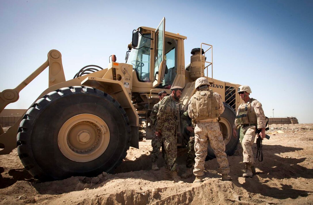 U.S. Marine Corps Lance Dustin Palmer, right, a heavy equipment operator with 2nd Combat Engineer Battalion, Regimental Combat Team 7 (RCT) 7, provides feedback to an Afghan National Army heavy equipment operator during a clearing operation near Camp Shorabak, Helmand Province, Afghanistan, March 16, 2013.  The operation was designed to eliminate possible enemy firing positions in preparation for the upcoming fighting season. (U.S. Marine Corps photo by Staff Sgt. Ezekiel R. Kitandwe/Released)