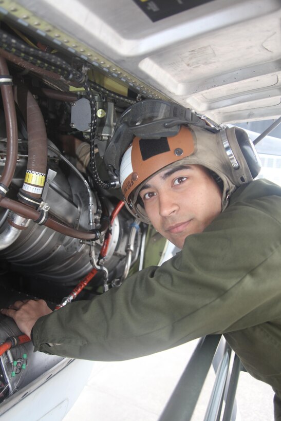 Pfc. Josh N. Villalobos looks at the camera as he works on the propeller engine of a KC-130J Hercules on the flight line infront of the Marine Aerial Refueler Transport Squadron 252 April 24. Villalobos spends mornings maintaining and fixing anything and everything that has to do with three vital pieces of the aircraft – propellers, engines and fuel lines. He conducts daily checks over all three systems each morning. Villalobos, a Cincinnati, Ohio, native, said the powerline Marines aren’t like other mechanics who deal with the whole aircraft. “Powerline deals with specifics. We have a lot of different moving parts we have to deal with and maintain,” he said. He is a powerline mechanic with VMGR-252.