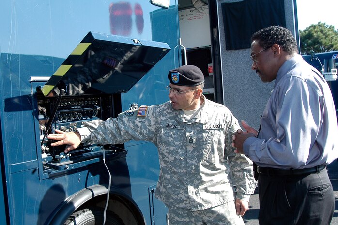 Sgt. 1st Class Munoz of the National Guard’s 8th Weapons of Mass Destruction - Civil Support Team, based at Buckley Air Force Base, Colo., demonstrates the capability of the communications truck at a display of WMD-CST vehicles during the NORAD Chemical, Biological, Radiological, Nuclear conference at Peterson Air Force Base, Colo., Aug. 29-31. The 8th WMD-CST is one of about 40 such teams nationwide that respond to emergencies involving chemical, biological, radiological, nuclear or high explosive agents or substances. Photo by Petty Officer 1st Class Shane Wallenda 