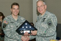Maj. Gen. Robert B. Ostenberg (right), director of Reserve Forces for the North American Aerospace Defense Command and U.S. Northern Command, presents Lt. Col. David Newberry with the Welcome Home Warrior-Citizen Award Jan. 20 at NORAD and USNORTHCOM headquarters. The award was mandated by Congress for all Army Reservists who have been activated in support of Operations Iraqi Freedom or Enduring Freedom. Photo by Tech. Sgt. Christopher Gish 