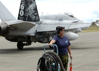 Corporal (Cpl) Chantal Lefebre, Avionic Systems Technician (AVS TECH) from 409 Squadron, prepares fire suppression system while Captain (Capt) Edward Miller, Pilot (PLT) from 409 Squadron prepares to take off from the Quick Response Area (QRA) in a CF-18 Hornet during Exercise Amalgam Dart
